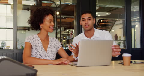 Diverse Colleagues Collaborating on Laptop Computer in Modern Office