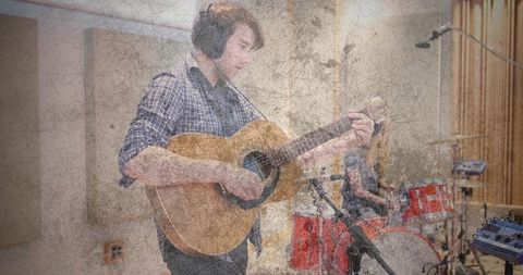 Musician Collaborating in Studio with Drummer in Background