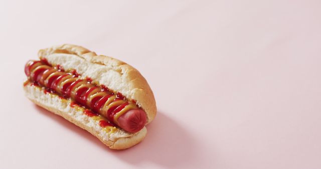Freshly prepared hot dog topped with ketchup and mustard served in a soft bun. Ideal for promoting fast food restaurants, food delivery services, or culinary blogs. Also suitable for use in marketing materials, social media posts, and menu designs.