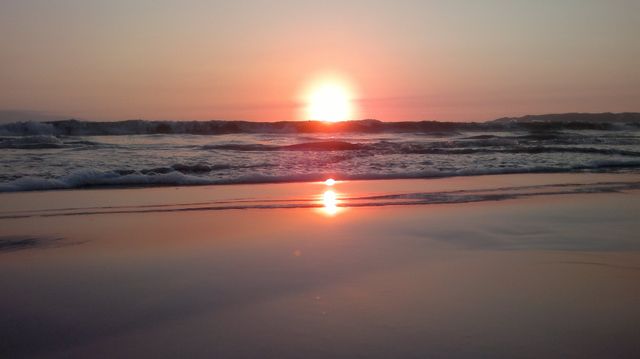 Serene Ocean Sunset Reflecting on Calm Beach Waters - Download Free Stock Photos Pikwizard.com