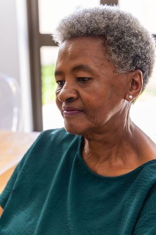 Senior african american woman reflecting quietly at home, thoughtful lifestyle portrait