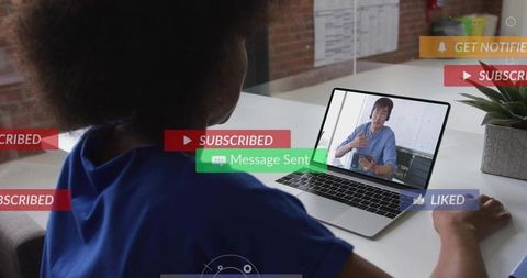 Woman watching remote presenter on laptop with social media notifications and modern desk