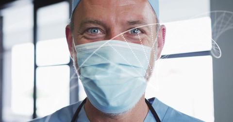 Smiling male clinician wearing mask and scrubs, closeup portrait with digital overlays