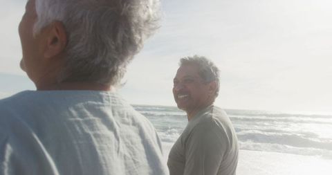 Senior Couple Enjoying Romantic Beach Walk During Sunset