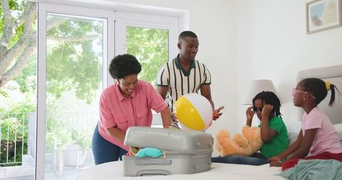 Family Packing Suitcase for Exciting Vacation in Cozy Bedroom
