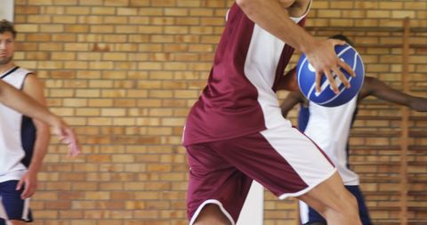 Basketball players competing intensely in indoor court