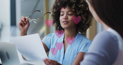 Colleagues Working Together with Heart Graphics Overlay in Modern Office