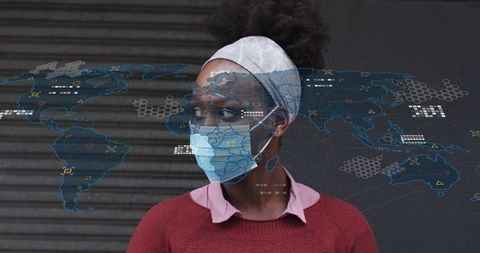 Young woman wearing surgical mask looking sideways with world map digital overlay