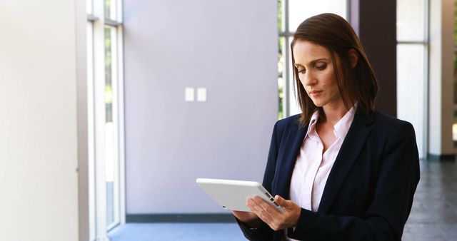 Businesswoman Working on Digital Tablet in Office Lobby - Download Free Stock Images Pikwizard.com