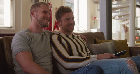 Happy Gay Couple Smiling on Cozy Couch Watching TV - Download Free Stock Images Pikwizard.com