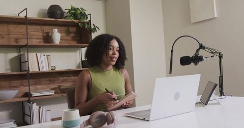 African american podcaster recording in minimal home studio with laptop and microphone