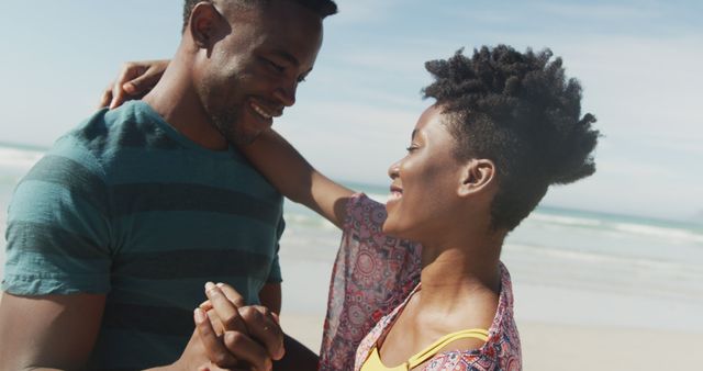 Happy african american couple dancing and holding hands on sunny beach - Download Free Stock Photos Pikwizard.com