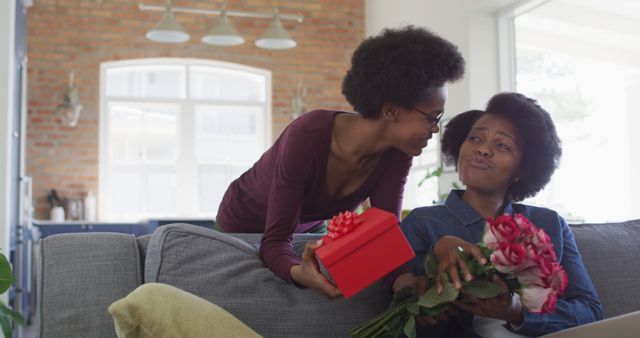 Daughter Gifting Flowers and Present to Smiling Mother at Home - Download Free Stock Images Pikwizard.com