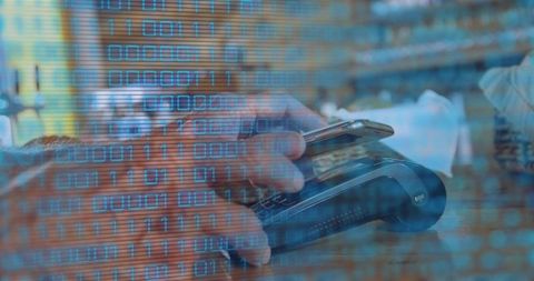 Senior man tapping smartphone for contactless payment at terminal with binary overlay