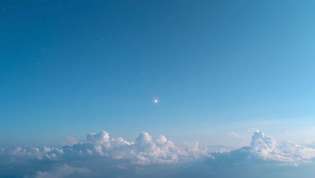 Celestial body illuminating night sky above clouds