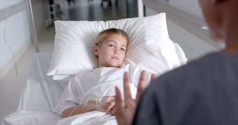 Young Patient Engaging in Conversation with Nurse in Hospital Bedside