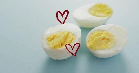 Hard-boiled egg halves with decorative hearts on blue background