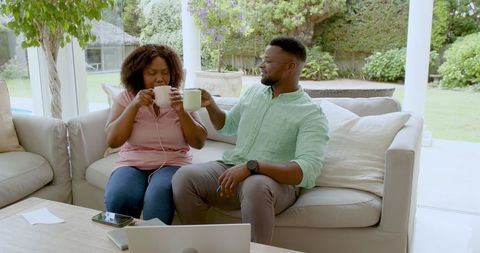 Mature Couple Enjoying Coffee Together While Relaxing on Sofa
