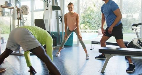 Group Fitness Class with Lively Stretching Routine in Bright Gym