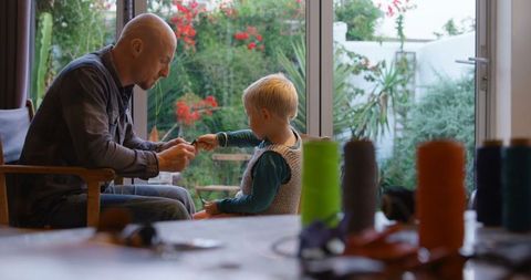 Father Teaching Son Craftsmanship with Keychain Project at Home