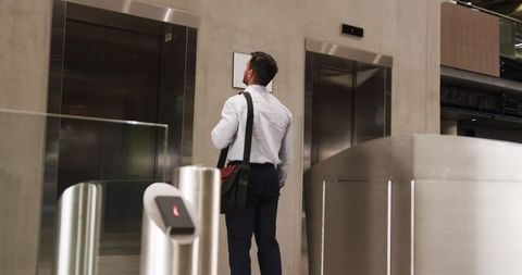 Professional Businessman Studying Elevator Options in Stylish Lobby