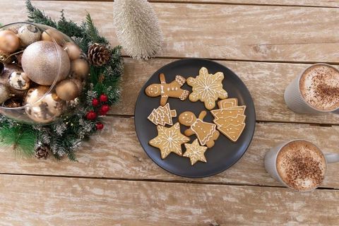 Serving Iced Gingerbread Cookies on Black Plate with Festive Wreath and Cocoa Mugs