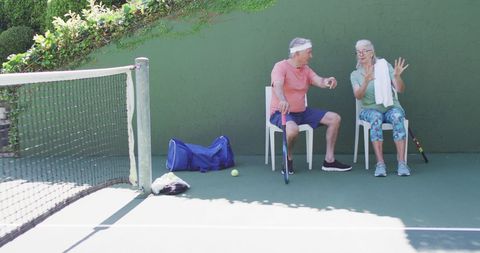 Senior couple taking break at outdoor tennis court