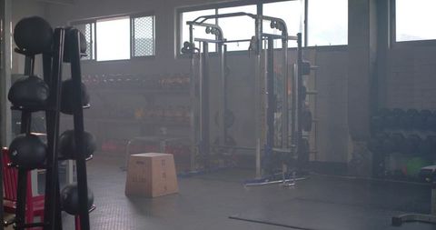 Industrial gym featuring multi-station power rack, plyo box, kettlebells and dumbbells