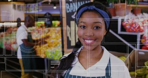 Smiling grocery store employee organizing fresh produce