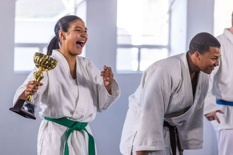 Excited Teen with Trophy in Karate Class Celebrating Achievement
