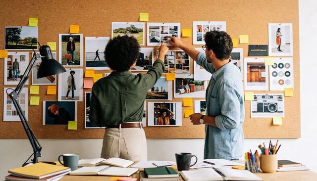Creating collaborative moodboard in creative studio with designers pinning visuals