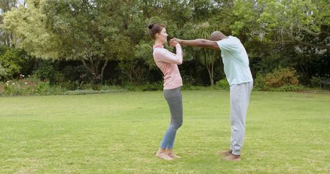 Diverse Workout Partners Stretching in Green Backyard