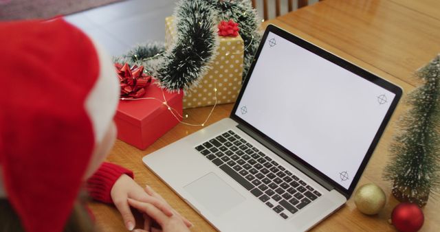 Caucasian woman wearing santa hat making image call at home on laptop with copy space on screen. christmas, communication technology and celebration.