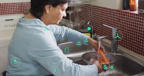 Senior woman washing vegetables at home kitchen sink