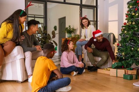 Diverse Family Gathering Near Christmas Tree With Gifts