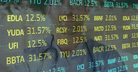 Male doctor standing behind glass wearing stethoscope with financial ticker overlay and health data