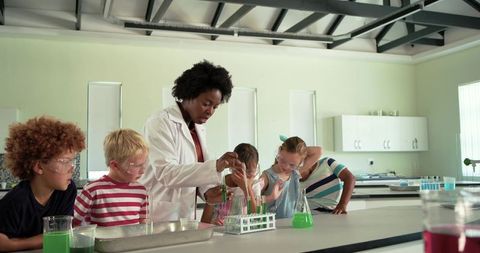African American teacher conducting science experiment with elementary students in lab