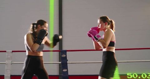 Women Sparring in Boxing Ring, Right-Side Boxer Holding Guard with Pink Gloves