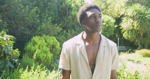 Contemplative man in sunlit garden embracing nature