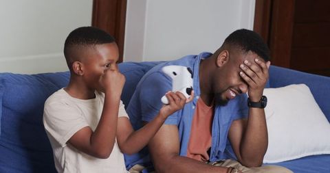 Father and Son Bonding Over Video Game in Living Room