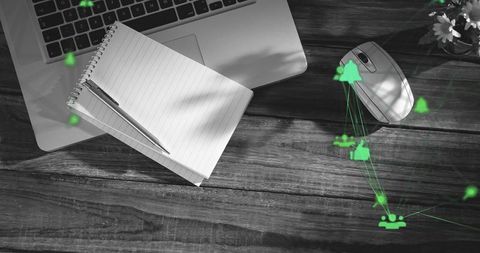 Minimalist workspace with laptop, spiral notebook and green digital network overlay