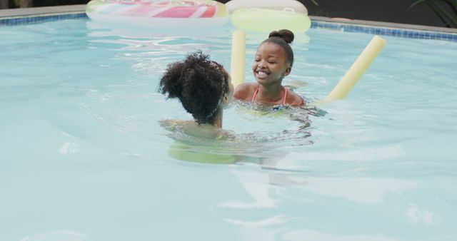 Two Happy Girls Playing in Pool with Noodles - Download Free Stock Images Pikwizard.com