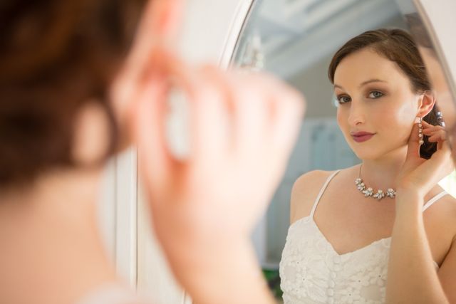 Beautiful bride in wedding dress looking into mirror - Download Free Stock Photos Pikwizard.com