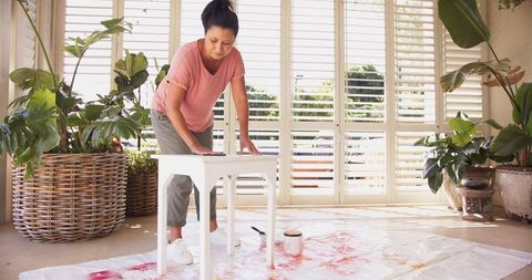 Woman focused on diy table painting home improvement project