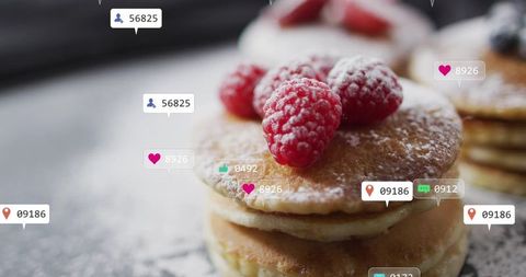 Stacking golden pancakes with raspberries and powdered sugar plus social media overlays
