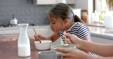 Mother and Daughter Enjoying Breakfast in Sunlit Kitchen