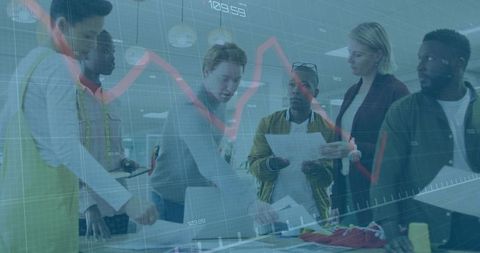 Diverse team collaborating in fashion design studio on colorful templates