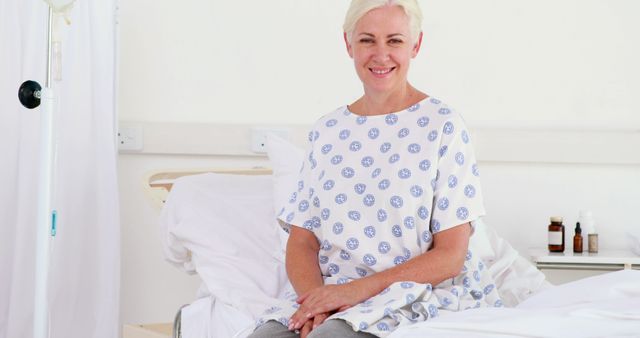 Smiling Patient in Hospital Gown Sitting on Bed - Download Free Stock Images Pikwizard.com