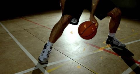 Dribbling basketball player showing low stance and quick footwork on indoor court