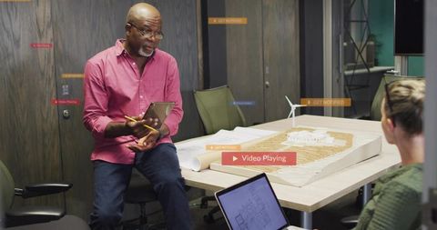 Leading architect presenting scale model in modern boardroom collaborative design meeting